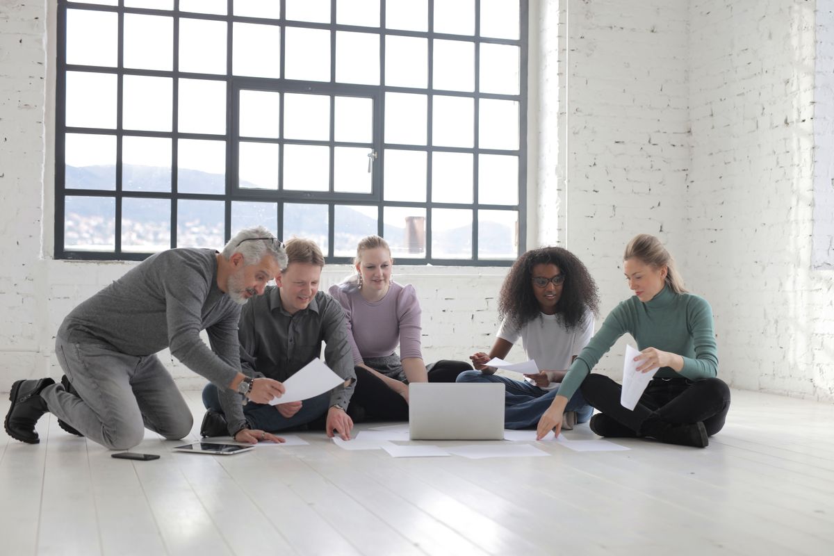 A team working together around a laptop and papers