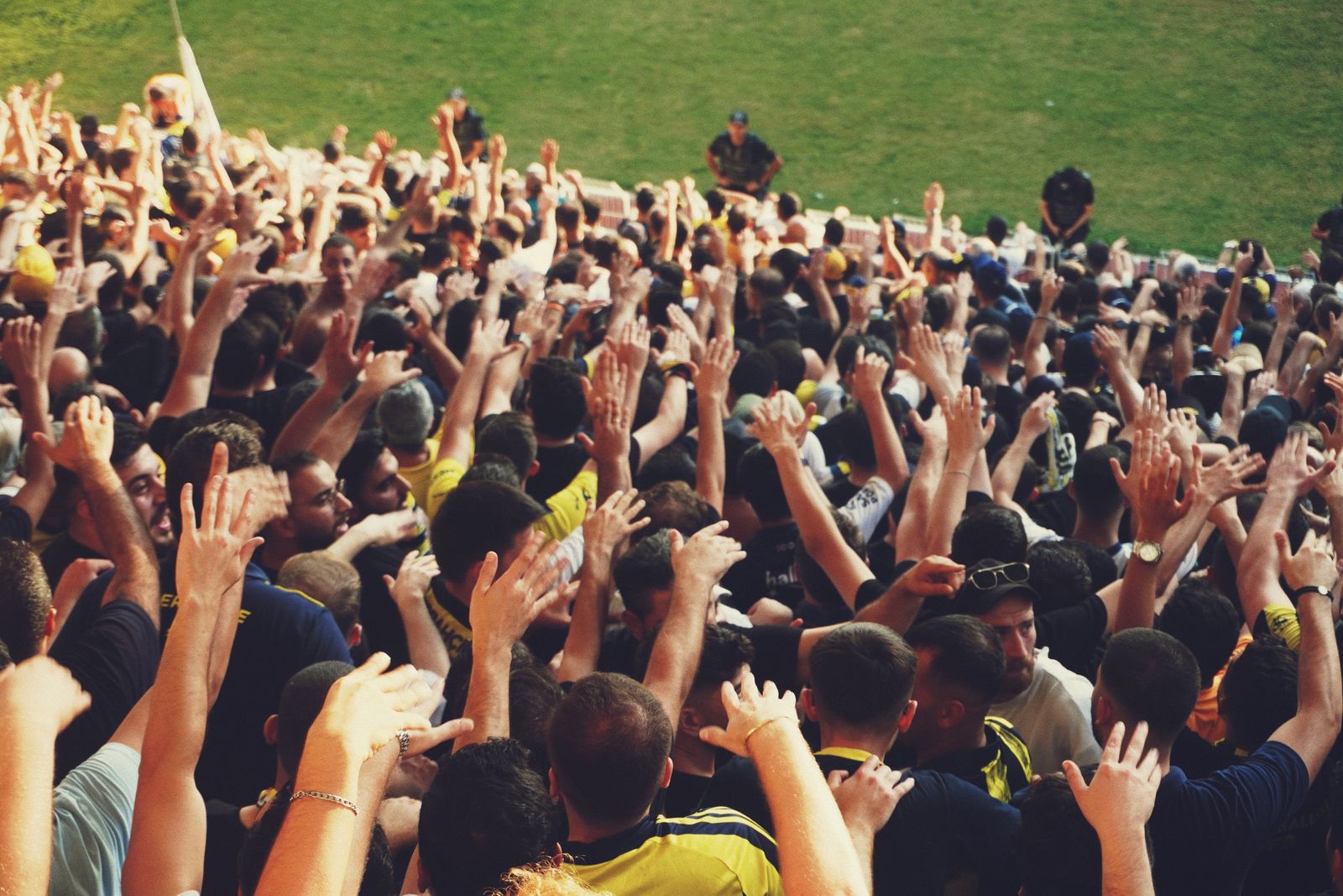 A large gathering of people with hands raised