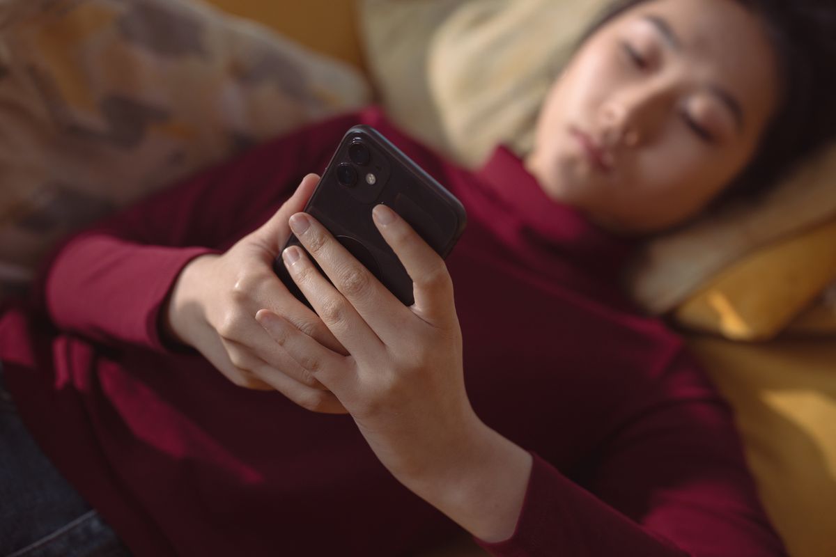 A person reading on a phone at home