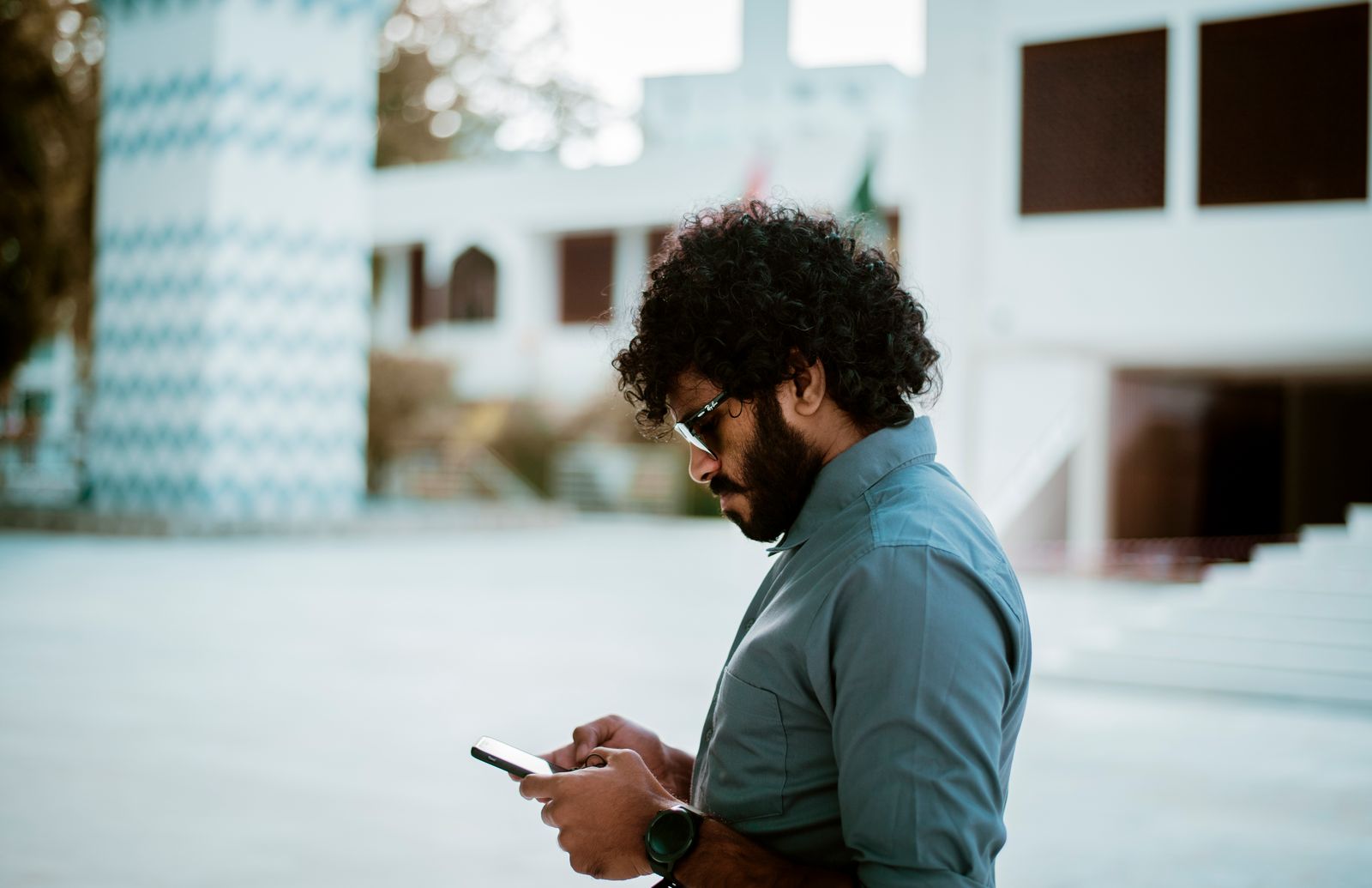 A man reading on his phone outdoors